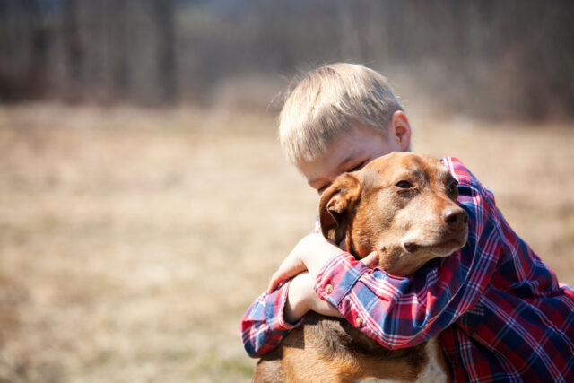 boy hugging dog
